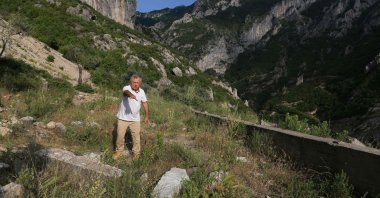 Archaeologist, Skender Mucaj inspects holes dug by illegal treasure hunters at the ruins of the Church of Saint Mary in Brrar, near Tirana, Albania, June 13, 2022. (AFP Photo)