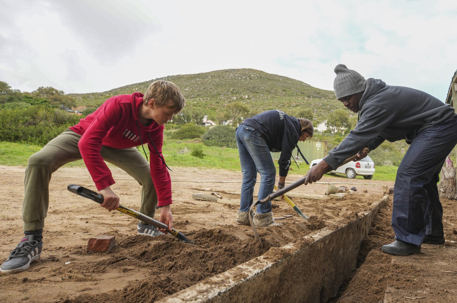 South African volunteers dig trenches for plants at Tears cat rescue center on International Mandela Day in Cape Town, South Africa, July 18 2022. (EPA Photo)