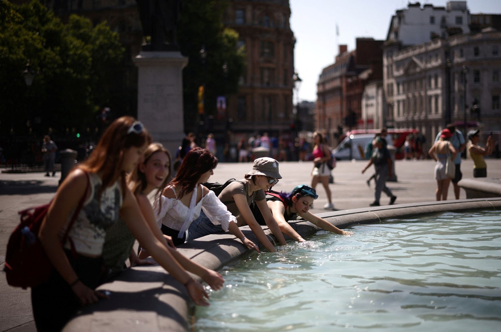 People cool off in a water fountain during a heatwave, at Trafalgar Square in London, U.K., July 19, 2022. (Reuters Photo)