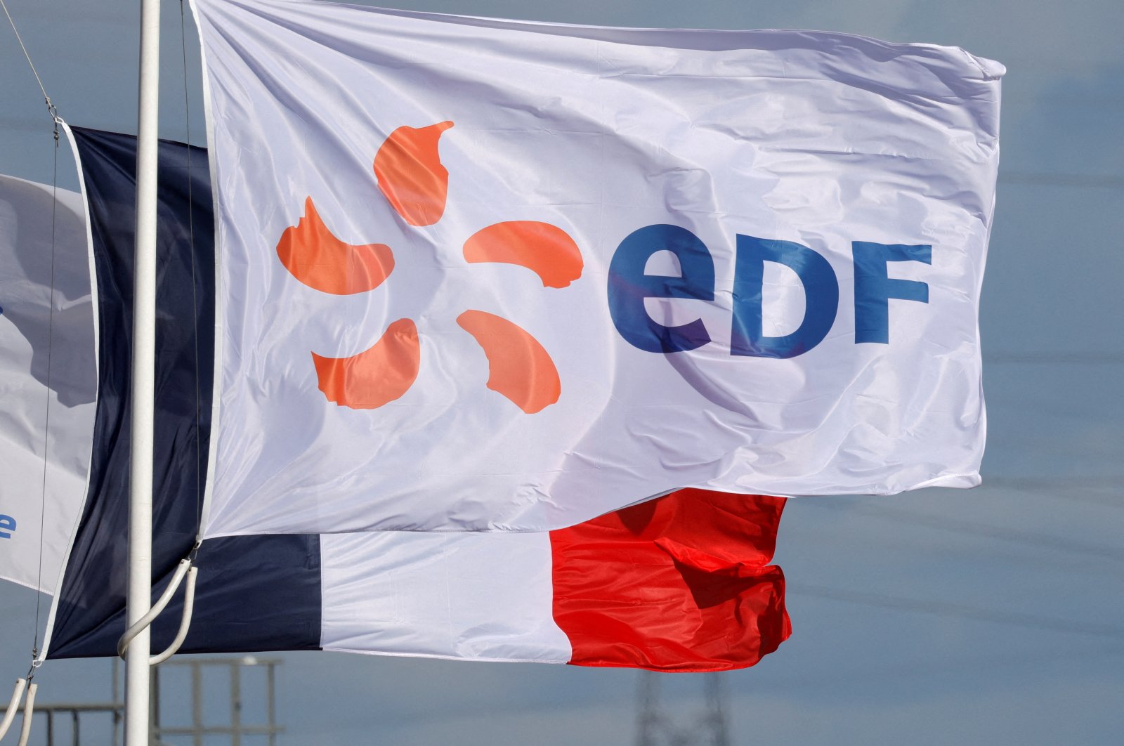 A flag with the company logo of Electricite de France (EDF) and the French flag fly next to the EDF power plant in Bouchain, near Valenciennes, France, Sept. 29, 2021. (Reuters Photo)