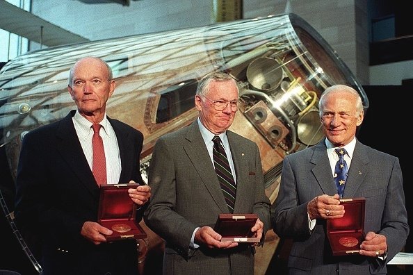 Awak Apollo 11 Michael Collins (kiri), Neil Armstrong (tengah) dan Buzz Aldrin berdiri di depan modul komando Apollo Columbia setelah Wakil Presiden AS Al Gore menganugerahkan mereka medali Samuel P. Langley di National Air and Space Museum di Washington, AS, 20 Juli 1999. (Getty Images)