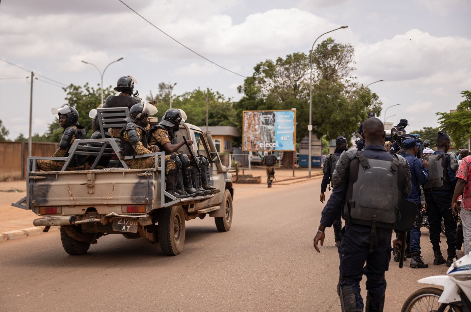 Security forces drive a vehicle near a crowd gathering awaiting the return of Blaise Compaore, former president of Burkina Faso, in front of Ouagadougou airport on July 7, 2022, eight years after he was forced into exile in Ivory Coast in 2014. (AFP Photo)