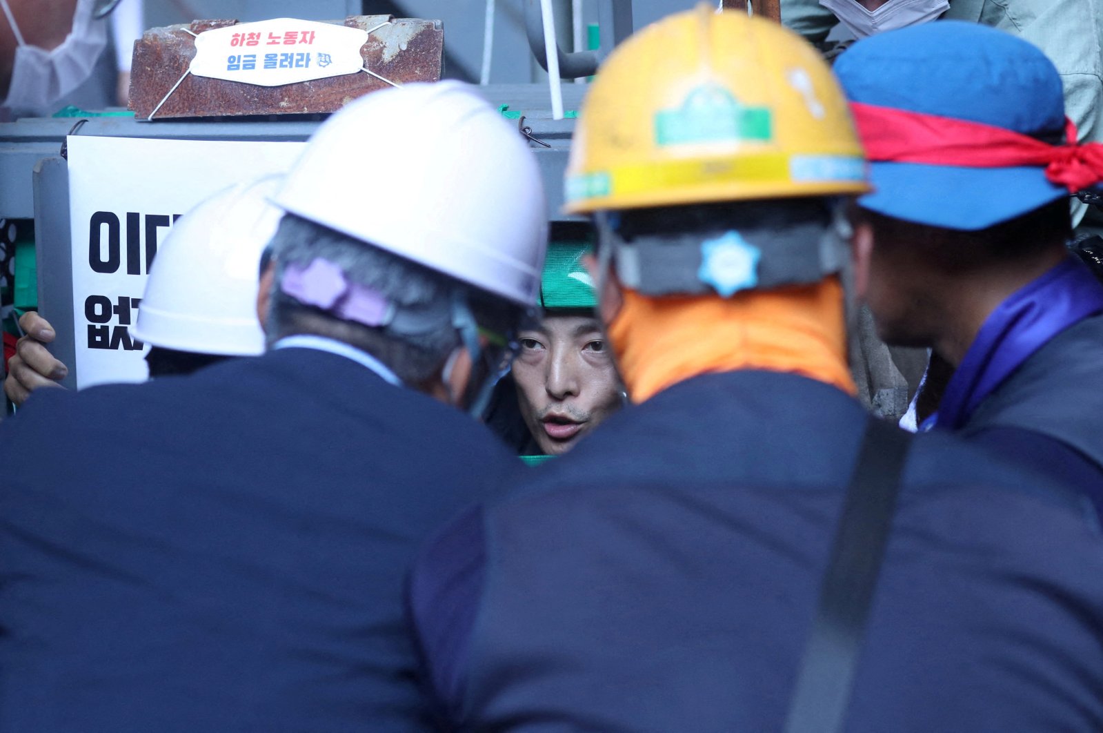 South Korea's Employment and Labor Minister Lee Jung-sik talks with Yoo Choi-ahn, vice chief of the subcontractor union, stuck inside a steel cage-like structure after welding himself to the floor of the occupied oil tanker during a strike at Daewoo Shipbuilding &amp; Marine Engineering in Geoje, South Korea, July 19, 2022. (Yonhap via Reuters )