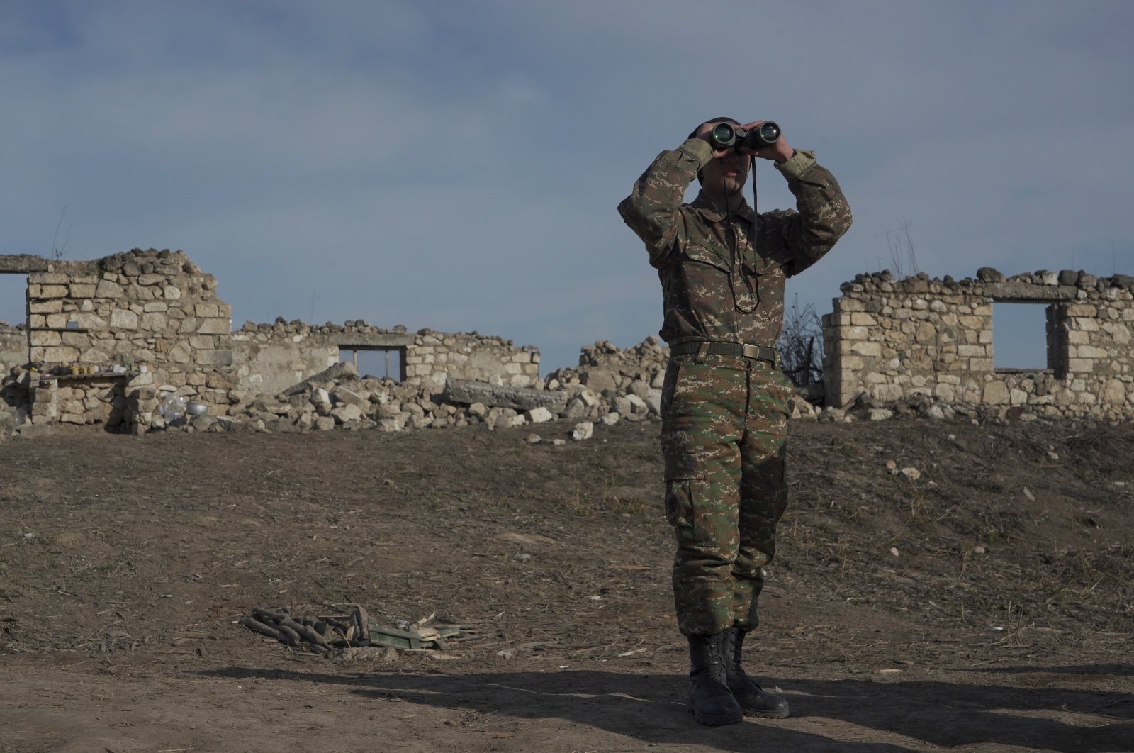 An ethnic Armenian soldier looks through binoculars as he stands at fighting positions near the village of Taghavard in the region of Karabakh, Jan. 11, 2021. (Reuters Photo)