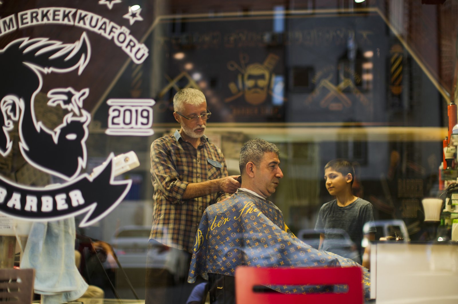 A client receives a haircut at a barber shop in Istanbul, Turkey, July 4, 2022. (AP Photo)