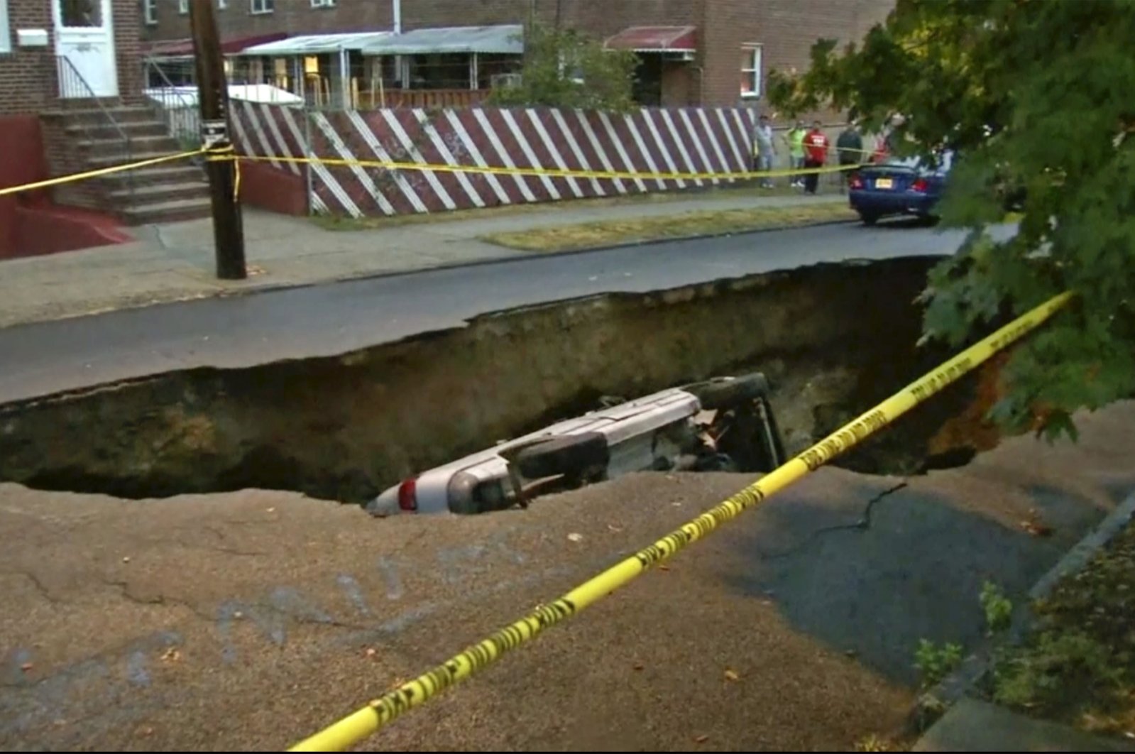 This still image from video shows a van that fell into a sinkhole, the length of three cars, that opened up in the Bronx borough of New York, U.S., July 18, 2022. (WABC-TV via AP)