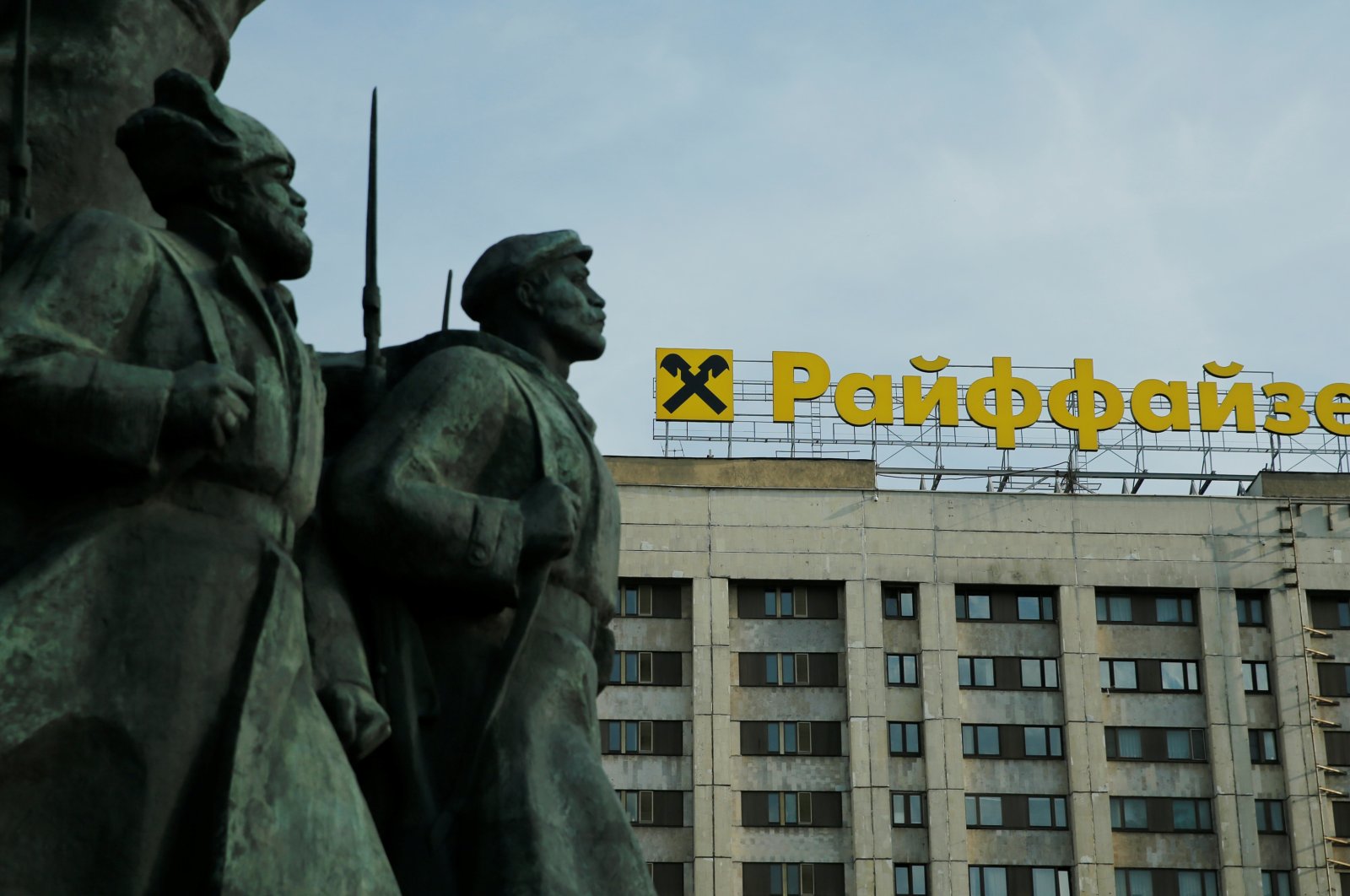 The logo of Raiffeisen Bank on top of a building is seen behind a fragment of a statue of Soviet state founder Vladimir Lenin, in Moscow, Russia, June 14, 2016. ( Reuters Photo)