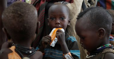 Turkana children eat food supplements given by Save the Children organisation during an outreach program in the drought hit Lorengo village, Turkana, Kenya, July 19 2022. (Reuters Photo)