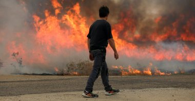 A man watches a fire burning a wheat field during the second heatwave of the year, Zamora, Spain, July 18, 2022. (Reuters Photo)