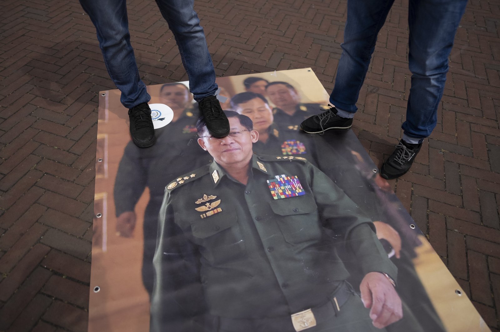 Pro-Rohingya demonstrators step on an image of Myanmar military Gov. Senior Gen. Min Aung Hlaing, outside the International Court of Justice in The Hague, Netherlands, Friday, July 22, 2022. (AP Photo)