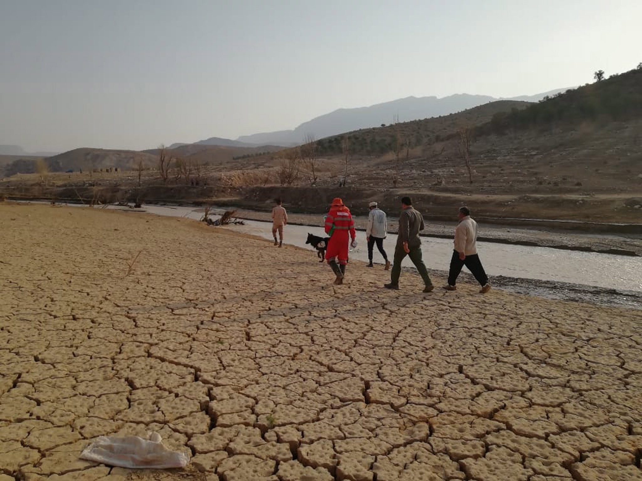 Foto selebaran yang disediakan oleh Masyarakat Bulan Sabit Merah Iran (IRCS) menunjukkan petugas penyelamat mencari di dekat tepi sungai setelah banjir di daerah Estehban, provinsi Fars, Iran selatan, 23 Juli 2022. (Foto EPA)