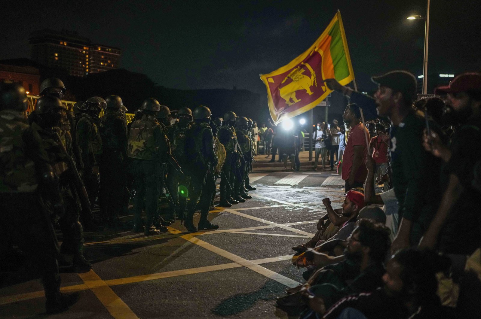 Army soldiers stand guard as protesters shout slogans at the site of a protest camp outside the Presidential Secretariat in Colombo, Sri Lanka, Jul. 22, 2022. (AP Photo)