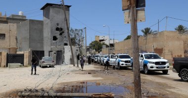 A convoy of cars transporting the Libyan Army's chief of staff arrives at a neighborhood in the capital Tripoli, bearing damage caused by recent fighting between armed groups. (AFP Photo)