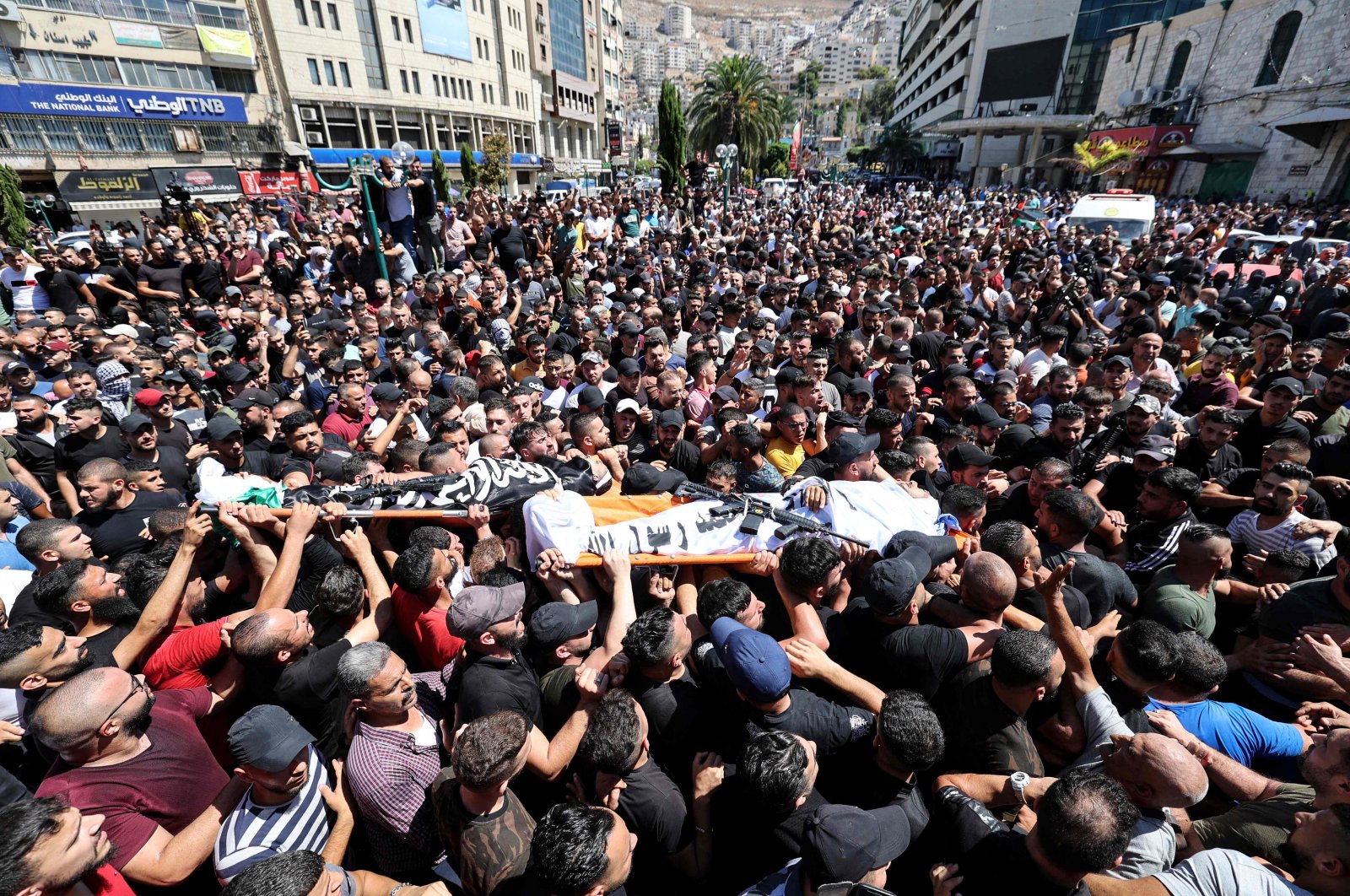 Mourners carry the bodies of two Palestinians killed by Israeli troops during their funeral procession in the West Bank city of Nablus, occupied Palestine, July 24, 2022. (AFP Photo)