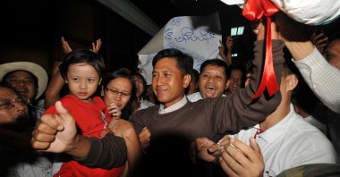 Kyaw Min Yu (C), known as Jimmy, and his wife Ni Lar Thein (L) holding her child, both members of the 88 Generation student group, celebrate upon their arrival at Yangon international airport following their release from detention, Myanmar, Jan. 13, 2012. (AFP File Photo)