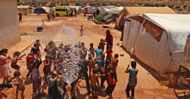 Children cool off at a camp for Syrians displaced by conflict near the Syrian border with Turkey in the opposition-held northern part of the northwestern Idlib province amidst high temperatures, Syria, July 20, 2022. (AFP Photo)