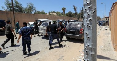 A convoy of cars transporting the Libyan army chief of staff, arrives at a neighborhood in the capital Tripoli on July 23, 2022, bearing damage caused by recent fighting between armed groups. (AFP)