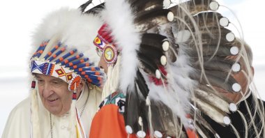 Pope Francis wears a traditional headdress he was given after his apology to Indigenous people for the Catholic Church's role in residential schools during a ceremony in Maskwacis, Alberta, Canada, July 25, 2022. (The Canadian Press via AP)