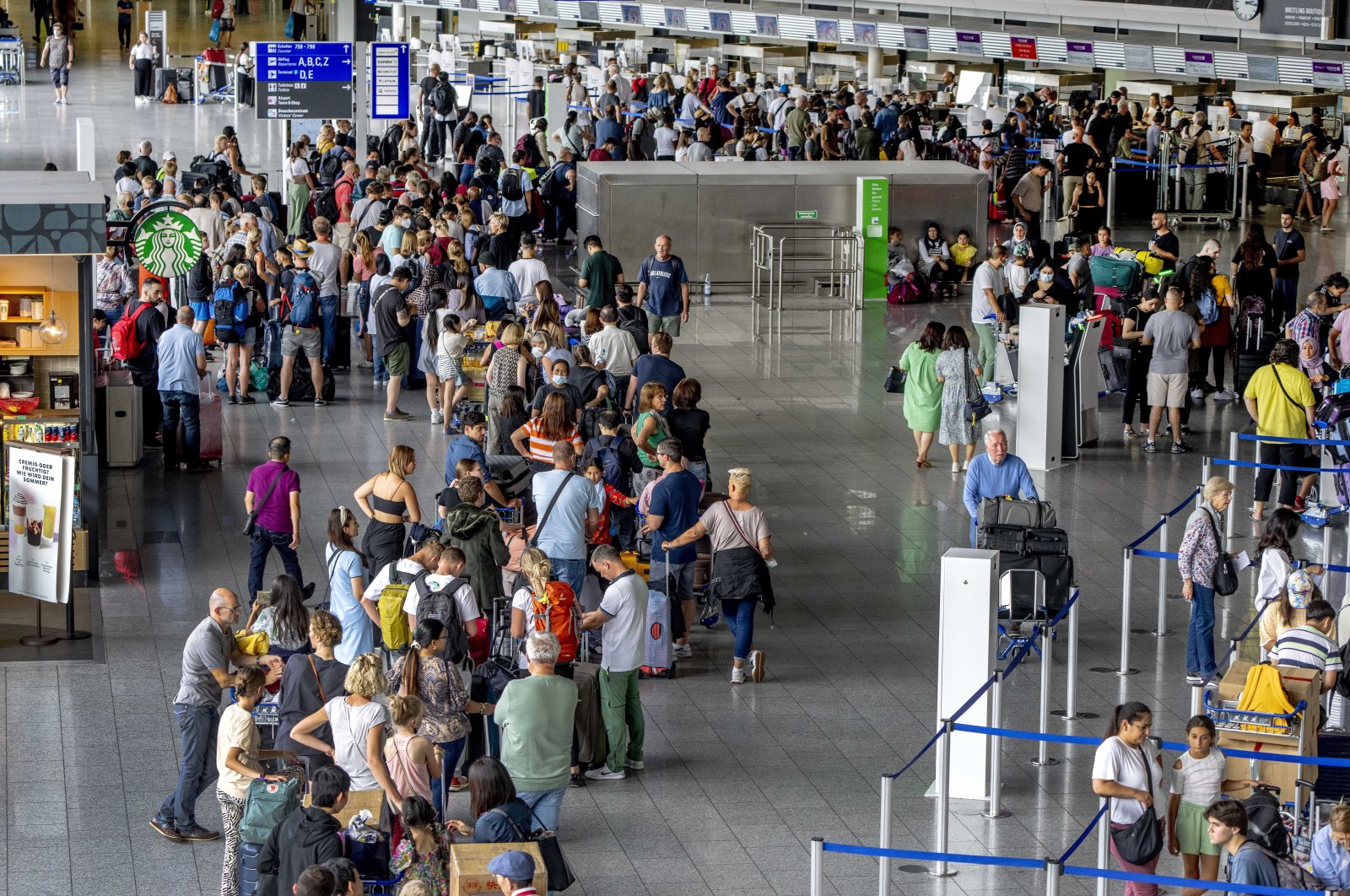 Passengers queue at the check in counters at the airport in Frankfurt, Germany, Monday, July 25, 2022. (AP Photo)
