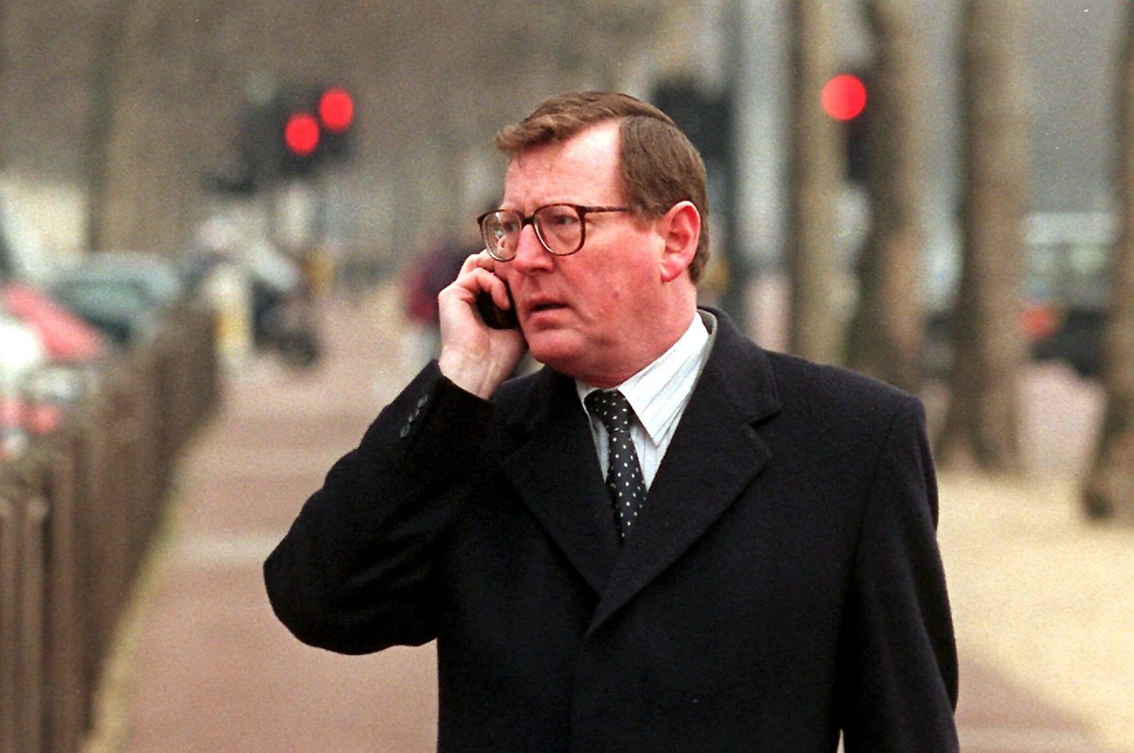Ulster Unionist Party leader David Trimble makes a mobile phone call in The Mall on his way to the final day of the all-party Northern Ireland peace talks at Lancaster House, London, Britain, Jan. 28, 1998. (EPA Photo)