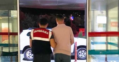 A gendarmerie officer escorts a detained suspect in Izmir, western Turkey, July 26, 2022. (AA PHOTO)
