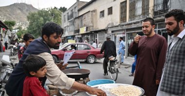 A vendor prepares roasted corn kernels for customers on the street in Kabul, Afghanistan, July 25, 2022. (AFP Photo)