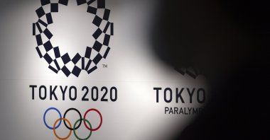 A person walks near Tokyo 2020 logo in Haneda Airport, Tokyo, Japan, June 14, 2021. (AP Photo)
