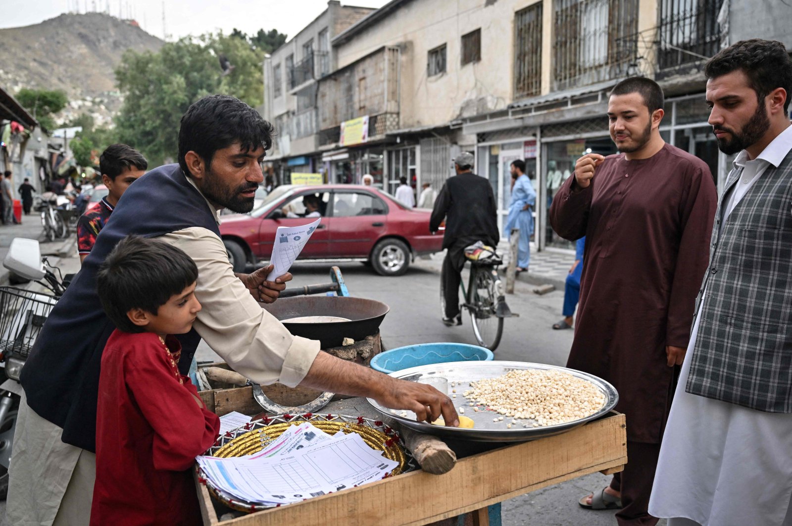 A vendor prepares roasted corn kernels for customers on the street in Kabul, Afghanistan, July 25, 2022. (AFP Photo)