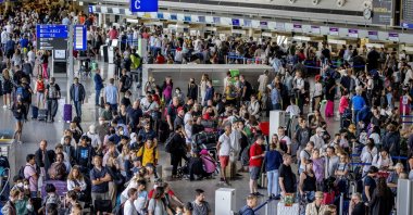 Passengers queue at check-in counters at the international airport in Frankfurt, Germany, July 27, 2022. (AP Photo)