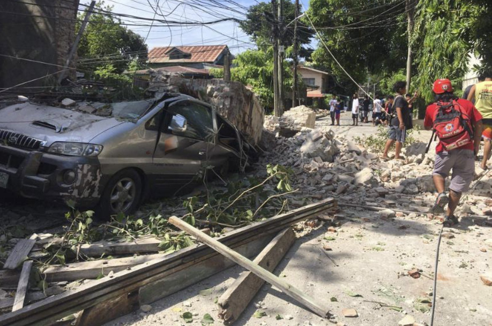 A vehicle is damaged by a collapsing wall after a strong earthquake hit Ilocos Sur province, Philippines, July 27, 2022. (Philippine Red Cross via AP)