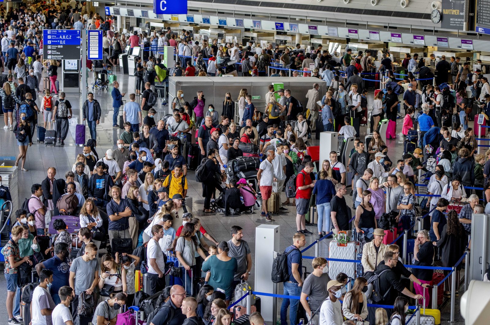 Passengers queue at check-in counters at the international airport in Frankfurt, Germany, July 27, 2022. (AP Photo)