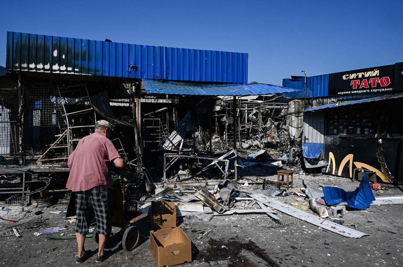A man stands next to the damage caused to the central market in Sloviansk by a suspected missile attack, Ukraine, July 6, 2022. (AFP Photo)