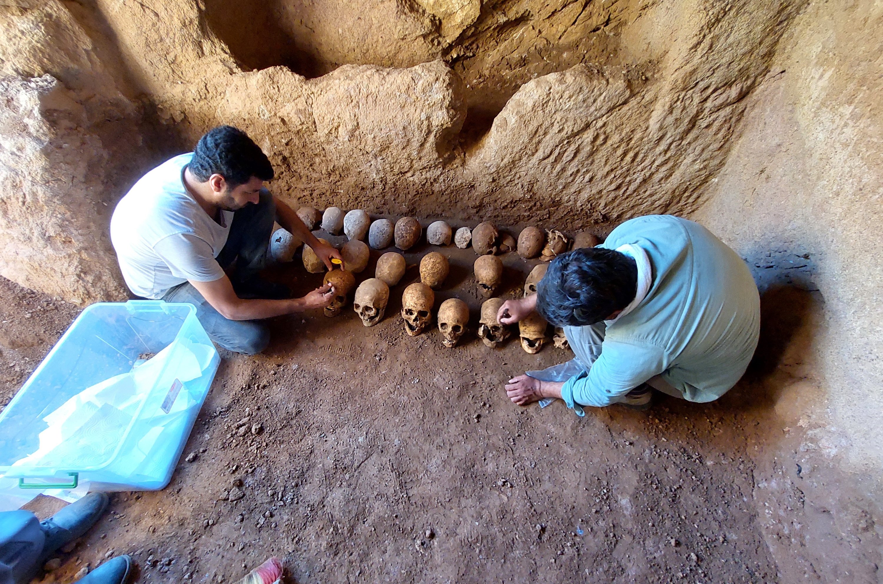Experts examine skulls found in the grave, in Adiyaman, eastern Turkey, July 28, 2022. (IHA PHOTO)