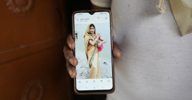 Sushil Kumar Bind displays a photograph of his wife Khushboo who was killed by lightning on June 25 in a paddy field at Piparaon village on the outskirts of Prayagraj, in the northern Indian state of Uttar Pradesh, July 28, 2022. (AP Photo)