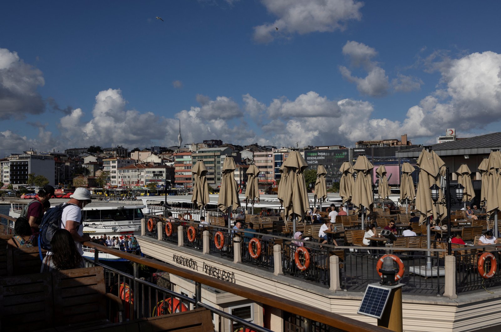 People on a ferry wait for berthing as others sit in a cafe in Istanbul, Turkey, July 20, 2022. (Reuters Photo)