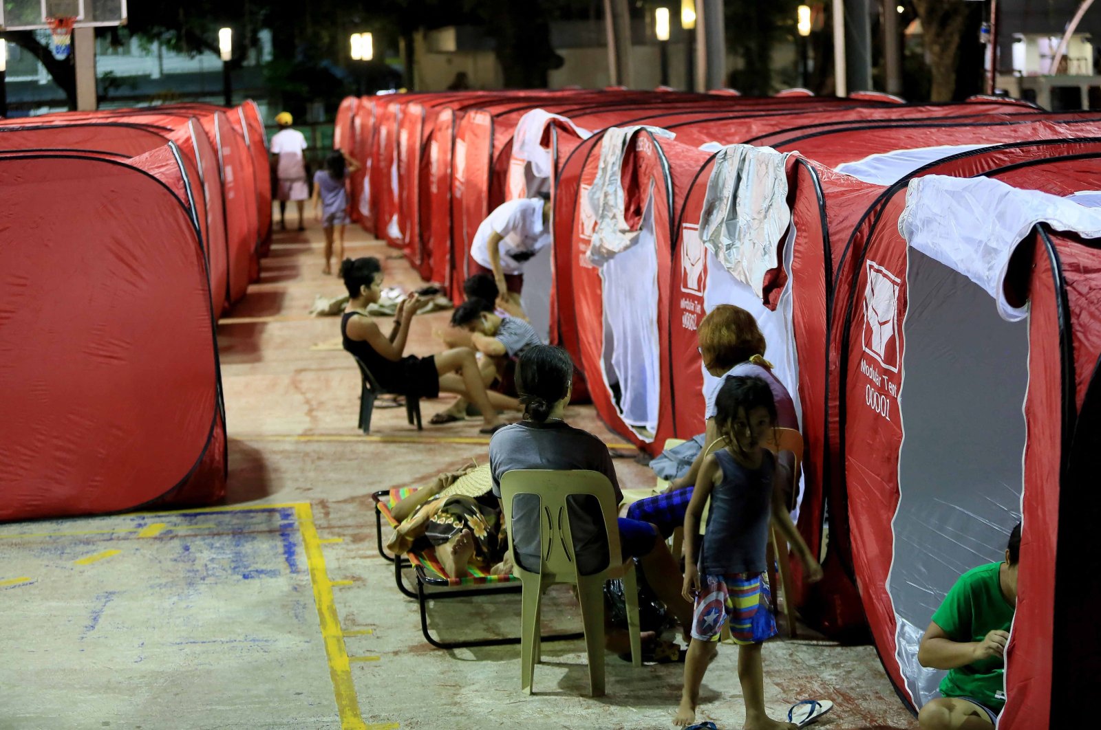 Residents rest at a temporary shelter set up on a basketball court in Bangued, in the province of Abra, the northern Philippines, July 27, 2022. (AFP Photo)