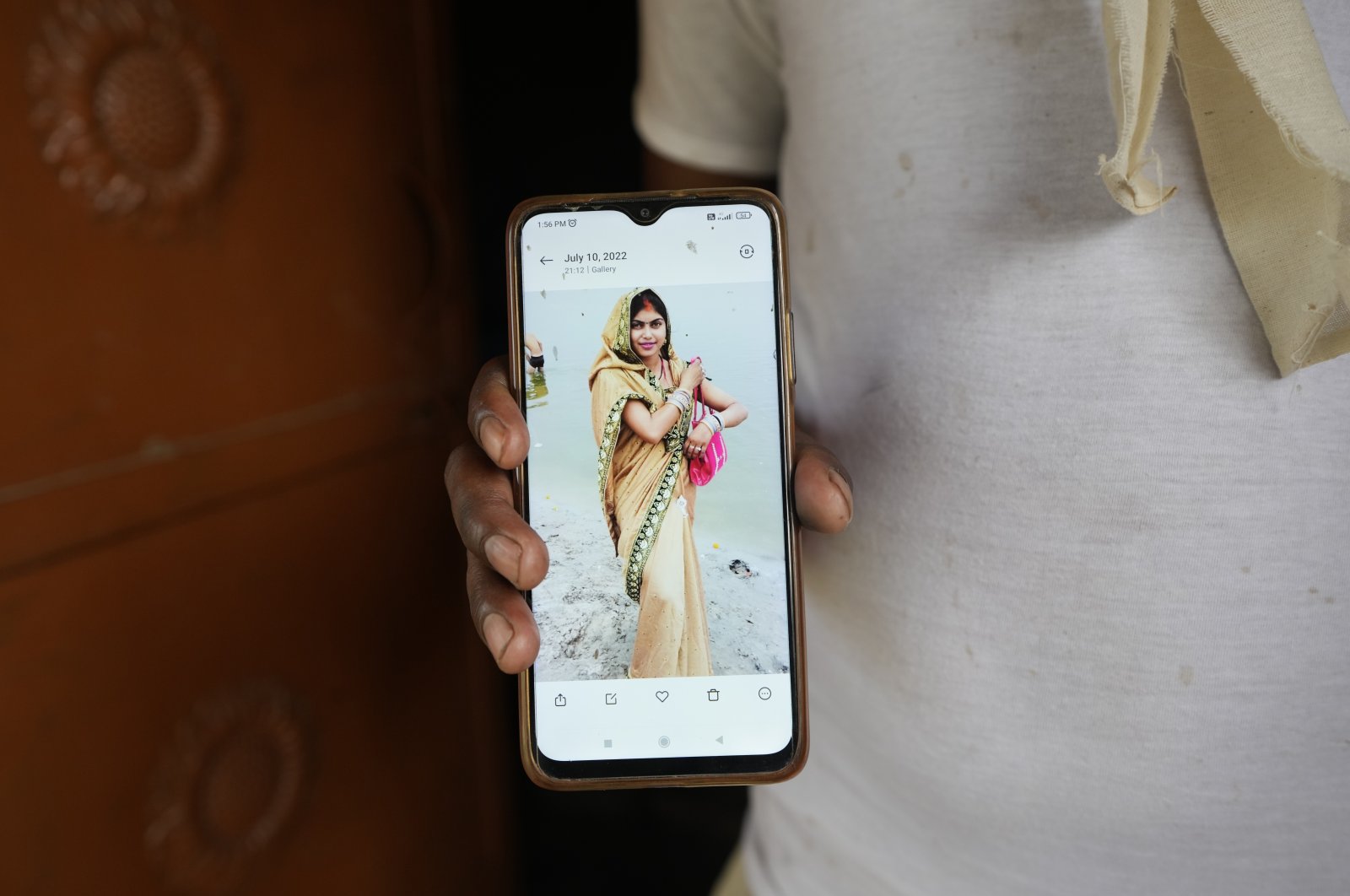 Sushil Kumar Bind displays a photograph of his wife Khushboo who was killed by lightning on June 25 in a paddy field at Piparaon village on the outskirts of Prayagraj, in the northern Indian state of Uttar Pradesh, July 28, 2022. (AP Photo)