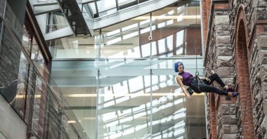 This image provided by Tapestry Opera shows Lauren Pearl climbing a wall as she performs the role of Louise in "Gould's Wall." (AP Photo)