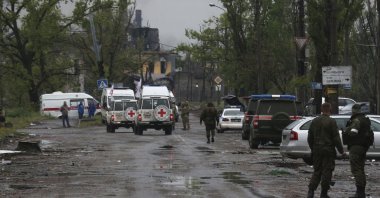 Red Cross staff drive by in their vehicles to the besieged Azovstal steel plant to observe the evacuation of Ukrainian servicemen in Mariupol, eastern Ukraine, May 18, 2022. (AP Photo)