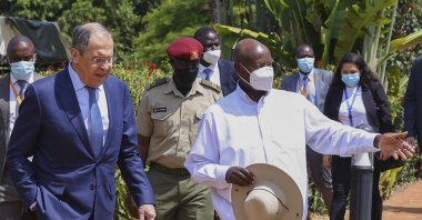 Russian Foreign Minister Sergey Lavrov (L) and Ugandan President Yowerei Museveni walk during their meeting in Entebbe, Uganda, July 26, 2022. (Russian Foreign Ministry Press Service via AP)