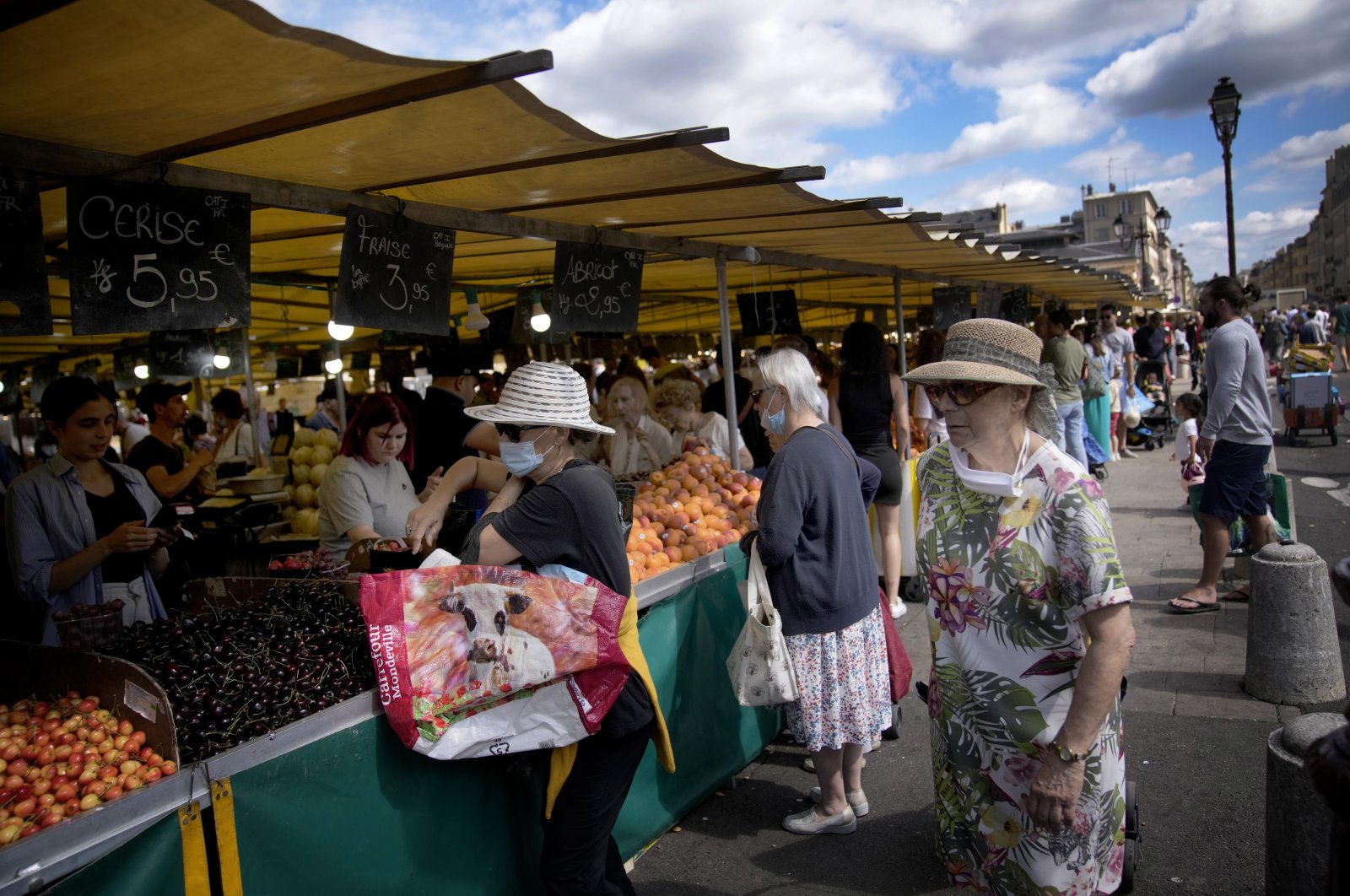 People shop at a market in Versailles, outside Paris, France, July 3, 2022. (AP Photo)