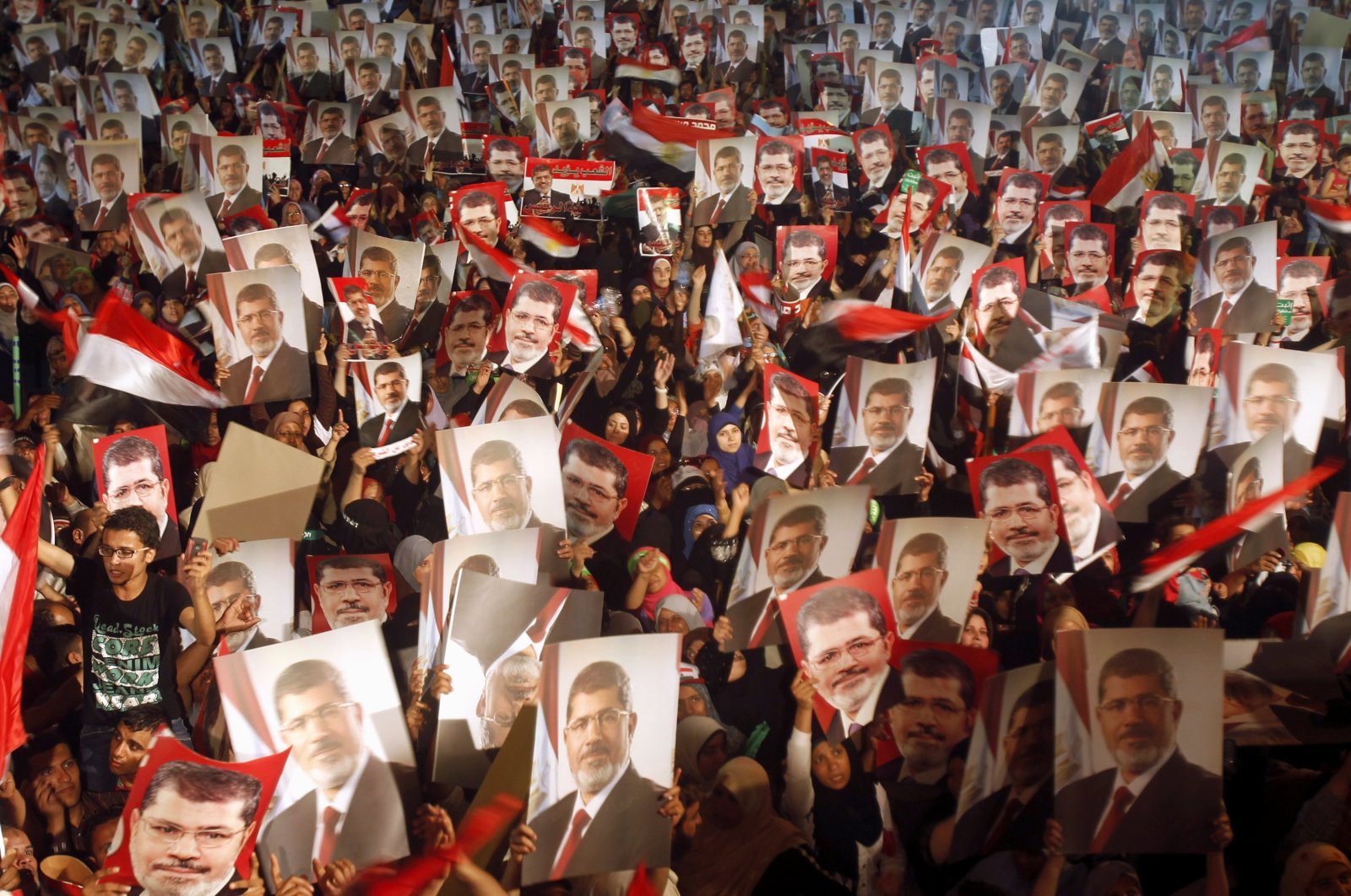 Members of the Muslim Brotherhood and supporters of then-Egyptian President Mohamed Morsi hold pictures of him as they react after the Egyptian army&#039;s statement was read out on state TV, at the Raba El-Adwyia mosque square in Cairo, Egypt, July 3, 2013. (Reuters File Photo)