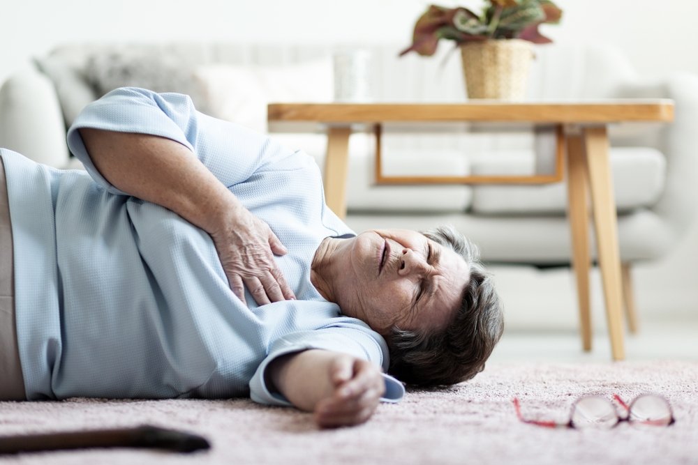 An elderly woman suffering a heart attack lying on the floor. (Shutterstock Photo)