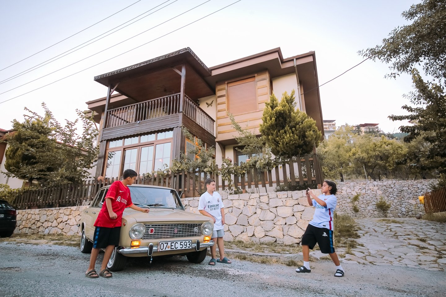 Local children take photos in front of Ömer Faruk Yılmaz&#039;s authentically restored Murat 124 model classic car, the Turkish-built version of Fiat&#039;s 124, Antalya, Turkey, July 11, 2022. (AA Photo)