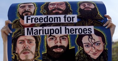 Victoria Dumych, whose husband serves in the Ukrainian military, holds up a sign in support of Ukrainian soldiers from the Azov Regiment who were captured by Russia in May after the fall of Mariupol, in Kyiv, Ukraine, July 30, 2022. (AP Photo)