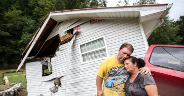 Reggie Ritchie comforts his wife Della as they pause while clearing out their destroyed manufactured home destroyed by the flooding from Troublesome Creek behind them in Fisty, Kentucky, U.S., July 29, 2022. (USA Today Network via Reuters)