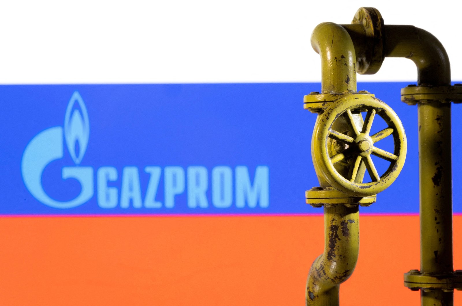 A 3D printed natural gas pipeline is placed in front of displayed Gazprom logo and Russian flag in this illustration taken Feb. 8, 2022. (Reuters Photo)