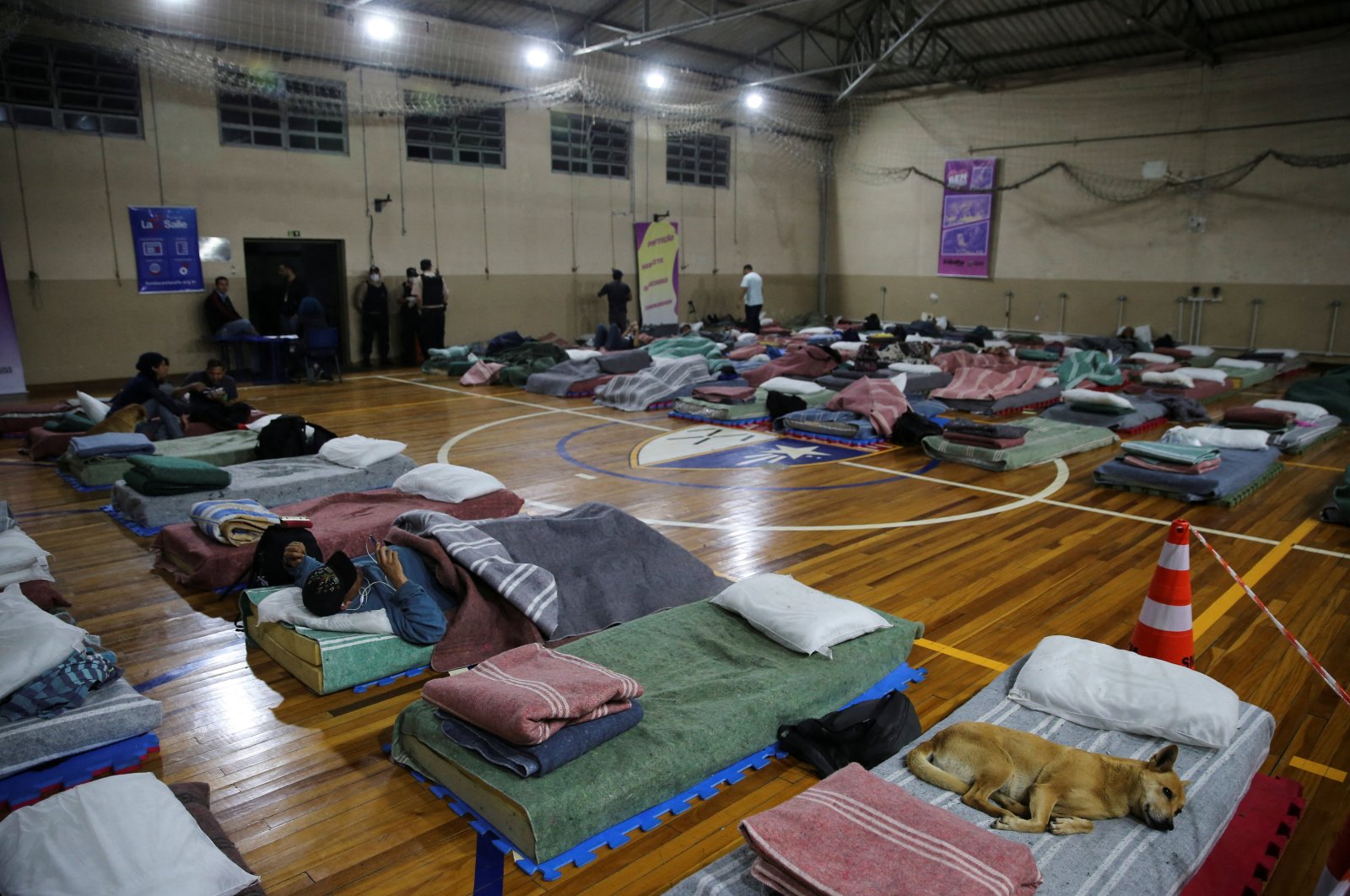 Homeless people rest with their animals in a shelter during low temperatures in Canoas, Brazil, July 26, 2022. (Reuters Photo)