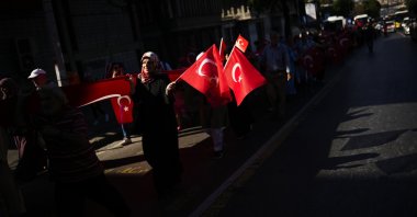 People wave Turkish flags as they rally to honor the victims of the July 15, 2016 failed coup attempt, in Istanbul, Turkey, July 15, 2022. (AP Photo)