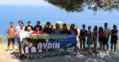 Young travelers staying in a dorm pose with a banner of the program, in Aydın, western Turkey, July 29, 2022. (İHA PHOTO)